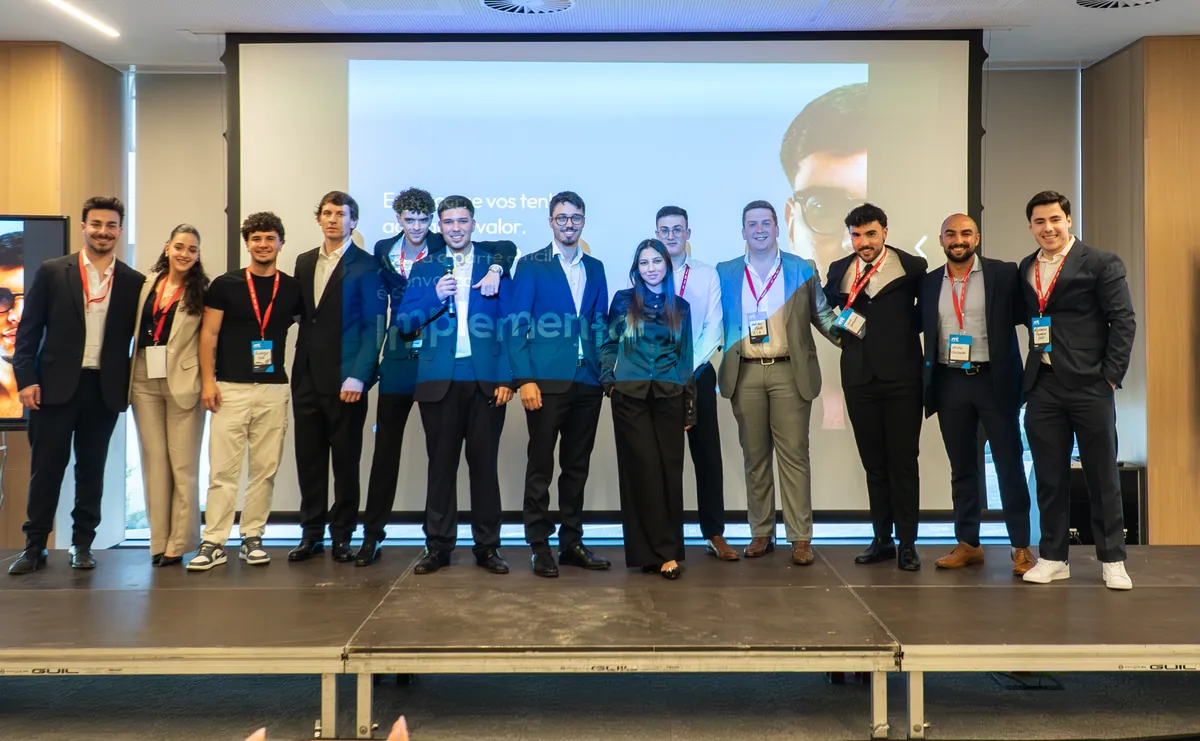 A equipa da BoomLab em palco, com a palavra Implementar projetada no ecrã